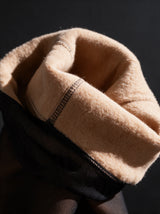 The warm beige plush fleece lining turned out against the sheer black outer knit